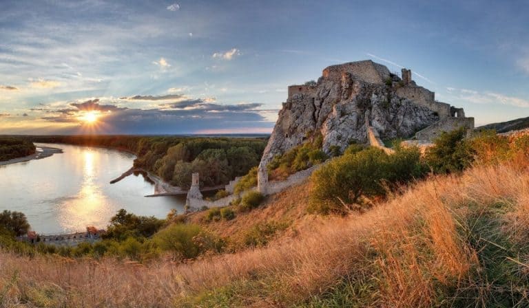 10 Wonderful Day Trips from Bratislava 1 Devin Castle in Slovakia during golden hour with the sun setting over the Danube River. An easy day trip from Bratislava!